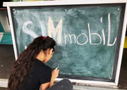 Mädchen beschriftet die Infotafel